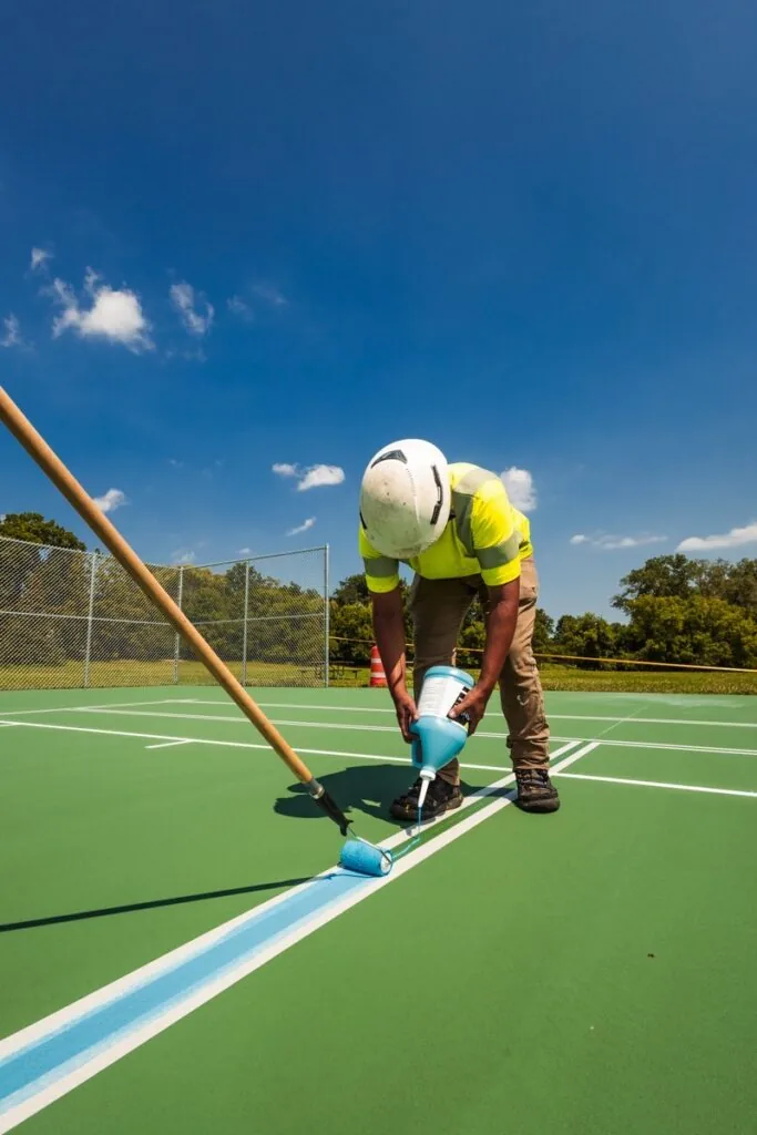 Man painting tennis court